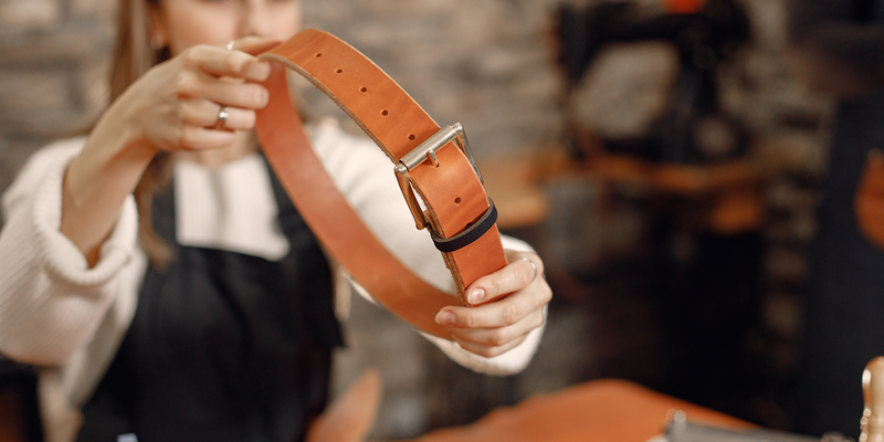 Artisane présentant une ceinture en cuir
