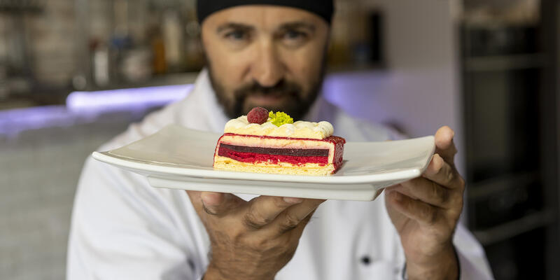 Artisan pâtissier montrant son dessert à l'assiette