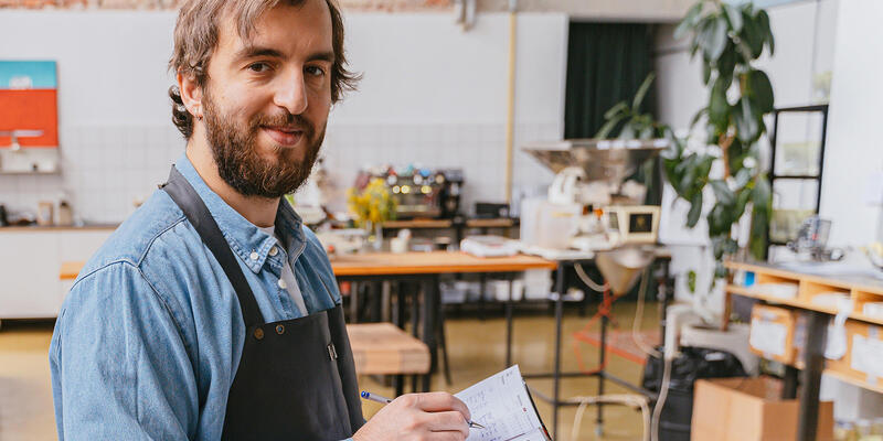Artisan dans son atelier en train de prendre des notes