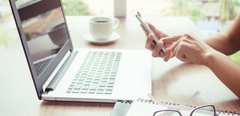 Artisane vérifiant son code NAFA sur son ordinateur et son téléphone