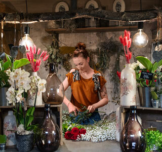 Artisane fleuriste réalisant un bouquet