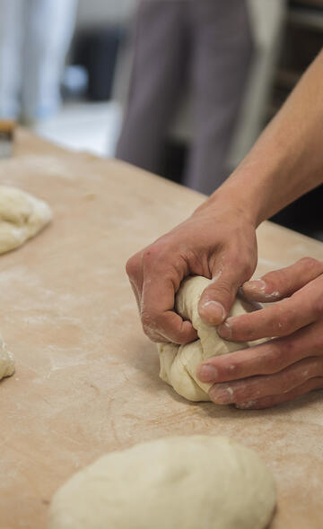Mains du boulanger qui travaillent la pâte
