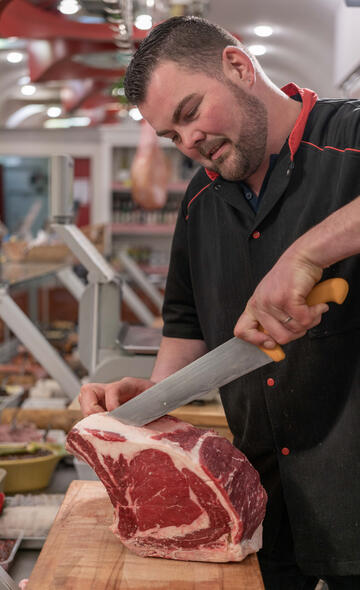 Artisan boucher découpant une pièce de boeuf