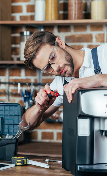 Artisan Répar'Acteur réparant une machine à café