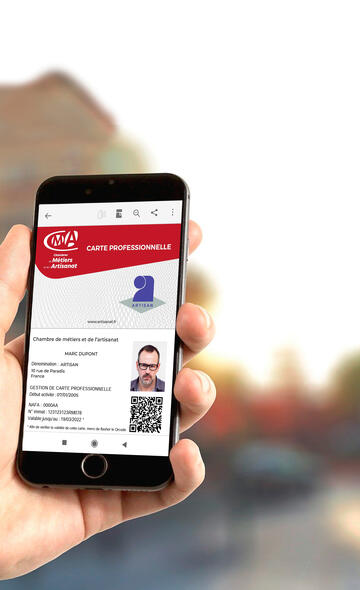 Artisan consultant sa carte professionnelle sur son téléphone