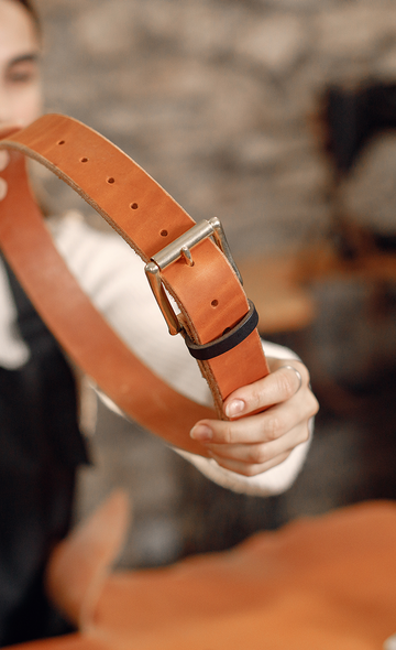 Artisane présentant une ceinture en cuir
