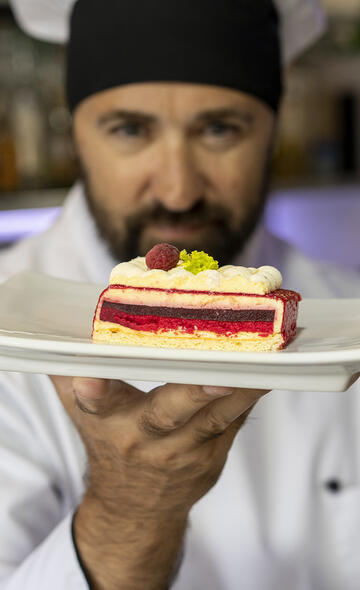 Artisan pâtissier montrant son dessert à l'assiette