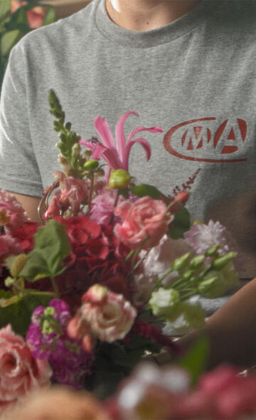 Artisane fleuriste portant un tee-shirt CMA en train de faire un bouquet