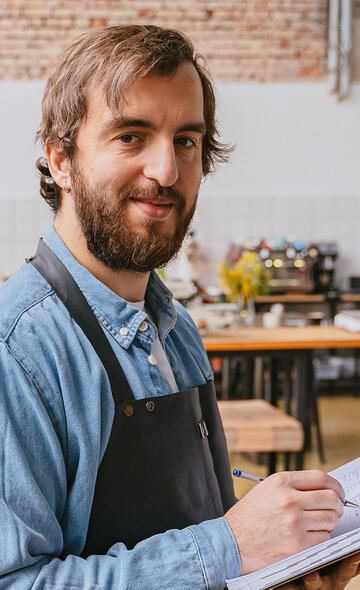 Artisan dans son atelier en train de prendre des notes