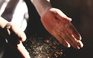 Mains de boulanger dans la farine