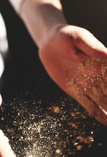 Mains de boulanger dans la farine