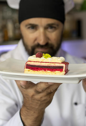Artisan pâtissier montrant son dessert à l'assiette