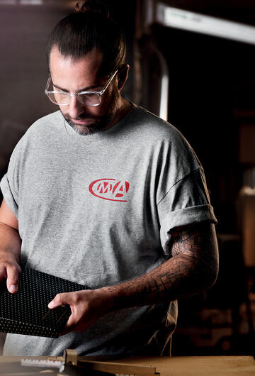 Menuisier portant un tee-shirt CMA en train d'observer sac en bois
