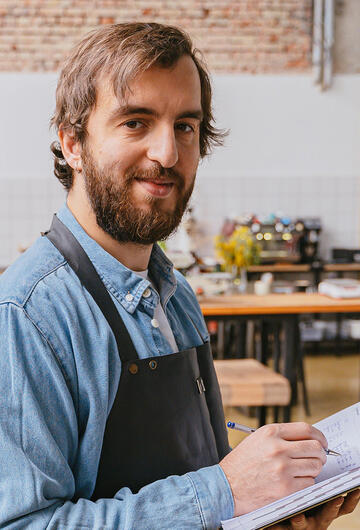 Artisan dans son atelier en train de prendre des notes