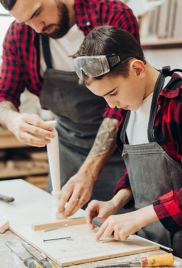 un jeune garcon en stage d'observation dans un atelier de menuiserie