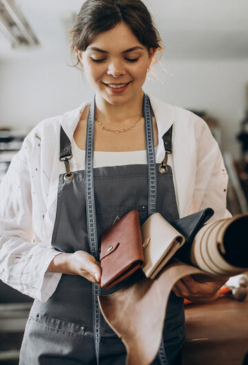 Micro-entrepreneuse montrant sa production de pochette en cuir