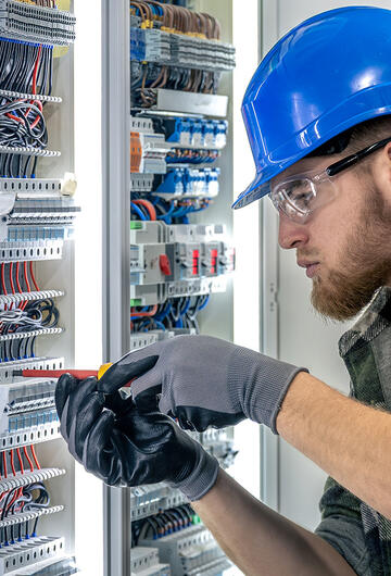 Jeune apprenti électricien travaillant sur un tableau électrique
