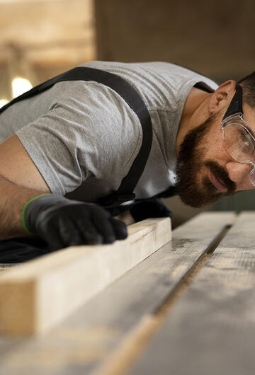 Artisan ébéniste coupant du bois à la scie circulaire