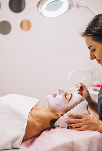 Artisane esthéticienne appliquant un masque à une cliente