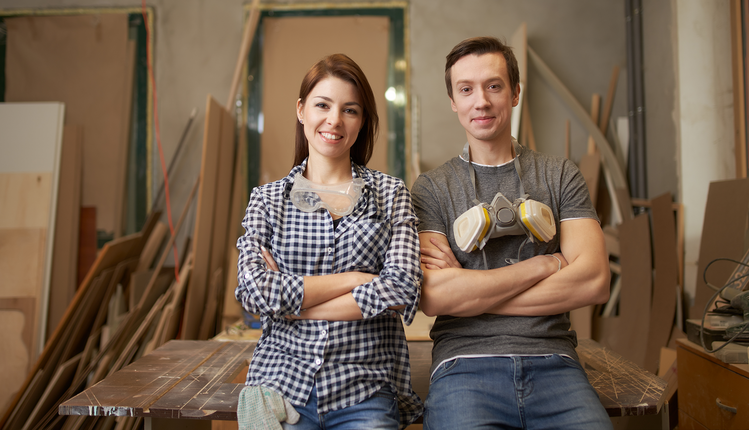 Menuisiers homme et femme dans leur atelier