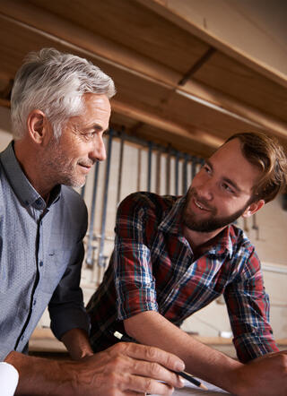 Deux artisans se souriant en parlant du projet de reprise