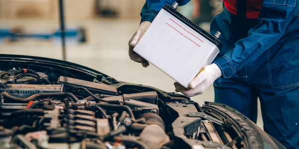 Artisan changeant la batterie d'une voiture