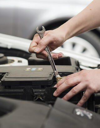 Main réparant un moteur de voiture