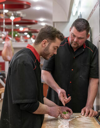 Artisan charcutier avec son apprenti