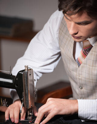 Artisan tailleur sur sa machine à coudre