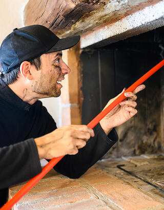 Artisan ramonant une cheminée