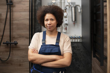 Plombière souriante dans la salle de bain qu'elle installe