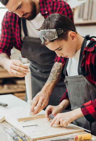 un jeune garcon en stage d'observation dans un atelier de menuiserie