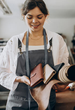 Micro-entrepreneuse montrant sa production de pochette en cuir