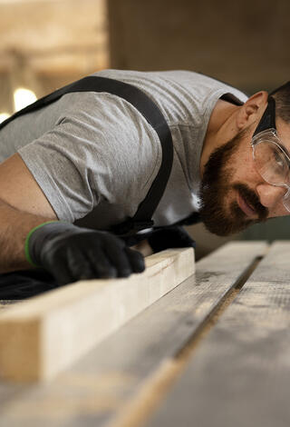 Artisan ébéniste coupant du bois à la scie circulaire