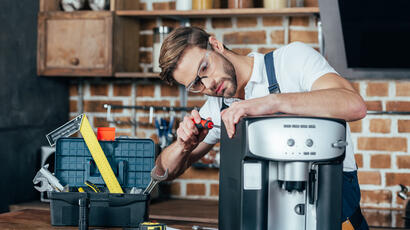 Artisan Répar'Acteur réparant une machine à café